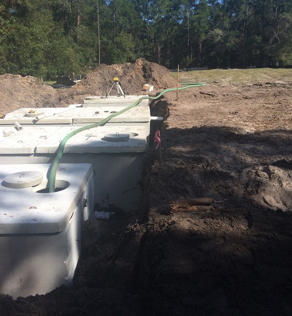 Concrete septic tank seated in a fresh excavation.