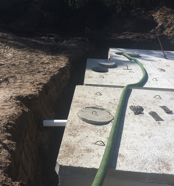 Concrete septic tank and open trench during an installation.