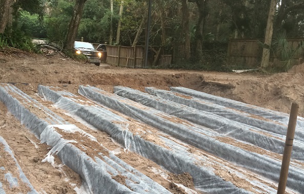 Drainfield trenches at a wooded job site.